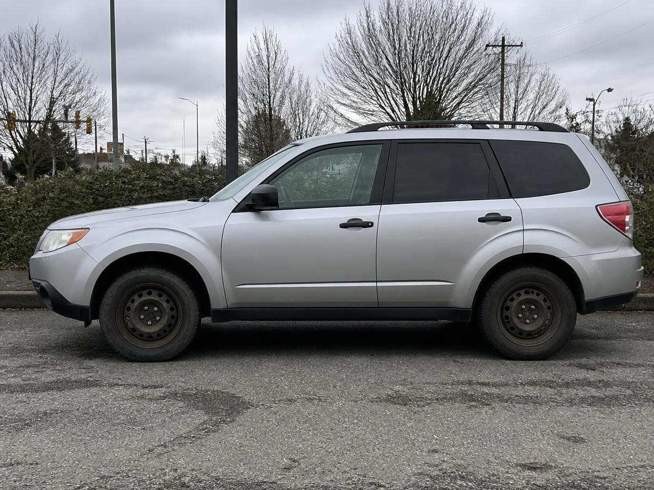 SUV with worn stock steel wheels before upgrade